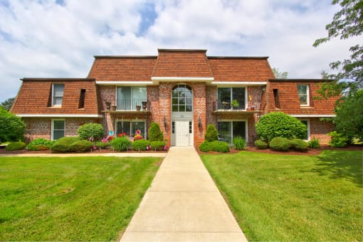 a large brick house with a sidewalk in front of it