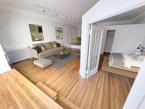 A living room with a striped sofa and a wooden floor.
