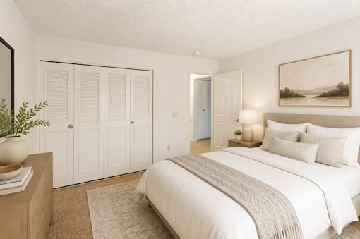 A bedroom with a large bed and a painting on the wall.