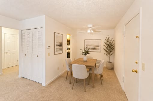 A dining room with a table and chairs.