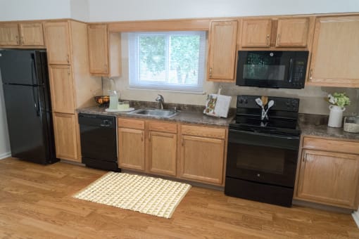 a kitchen with black appliances and wooden cabinets