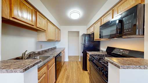 A kitchen with wooden cabinets and black appliances.