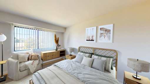 A bedroom with a large bed, a chair, and a couch.