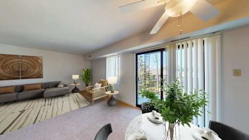 A living room with a grey sofa, a white coffee table, and a ceiling fan.