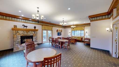 a dining room with a stone fireplace and tables and chairs