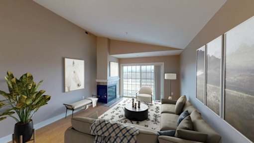 A living room with a couch, a coffee table, and a large window.