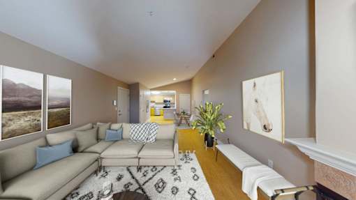 A living room with a couch, a rug, and a painting on the wall.