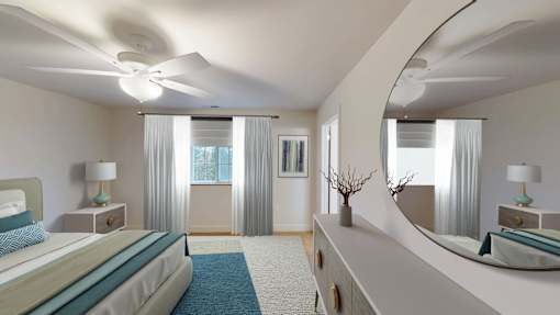 A bedroom with a large bed and a mirror on the dresser.
