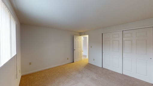 a bedroom with two closets and a door to a hallway