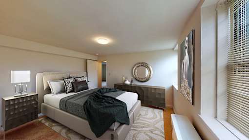 A bedroom with a large bed and a mirror on the wall.