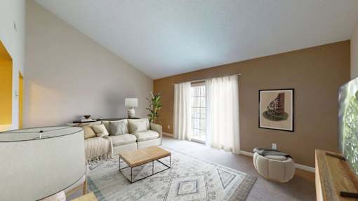 A living room with a grey sofa, a coffee table, and a painting on the wall.