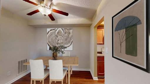 A dining room with a table and chairs and a ceiling fan.