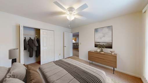 A living room with a grey sofa and a ceiling fan.