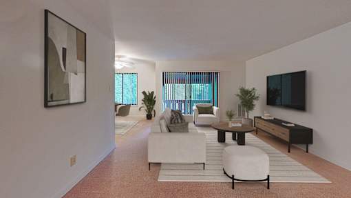 A living room with a white couch, a coffee table, and a television.