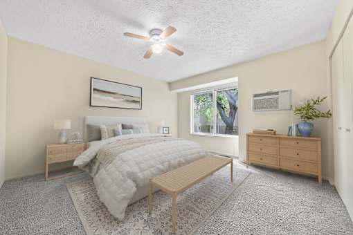 A bedroom with a bed, nightstand, and a ceiling fan.
