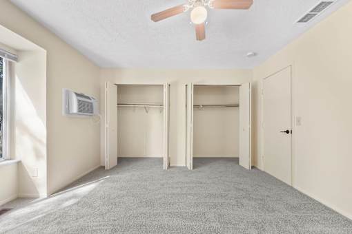 A room with a ceiling fan and a window.