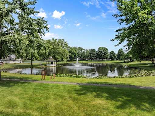 A serene park with a pond and a gazebo.