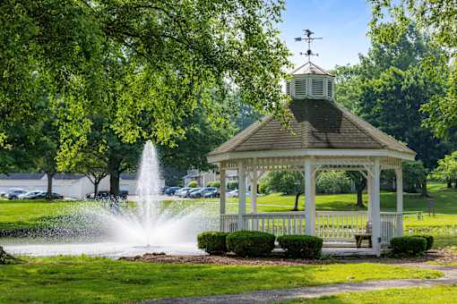 A gazebo with a fountain in front of it.