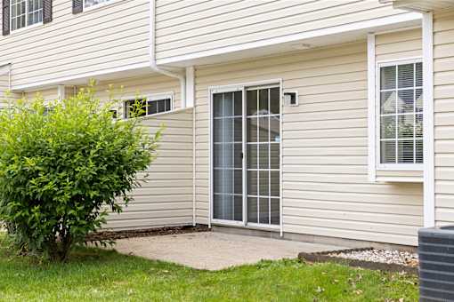 A house with a grey siding and a white window.