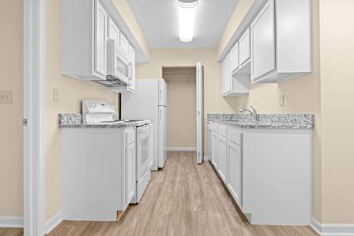 A kitchen with white appliances and cabinets.