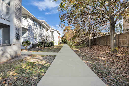 A concrete walkway leads between two rows of houses.