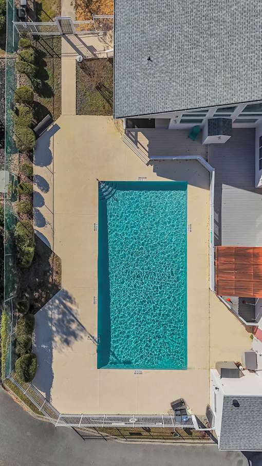 A rectangular pool with a concrete floor and a concrete wall surrounding it.