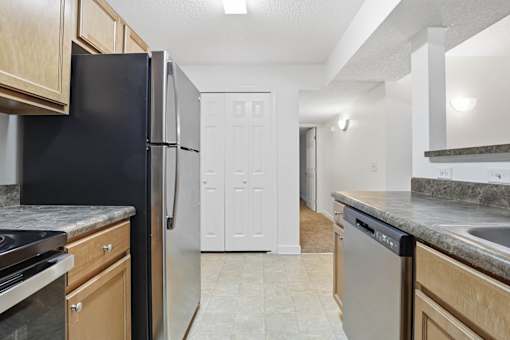 A kitchen with black appliances and wooden cabinets.