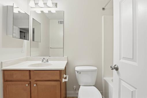 A white toilet sits next to a sink in a bathroom.