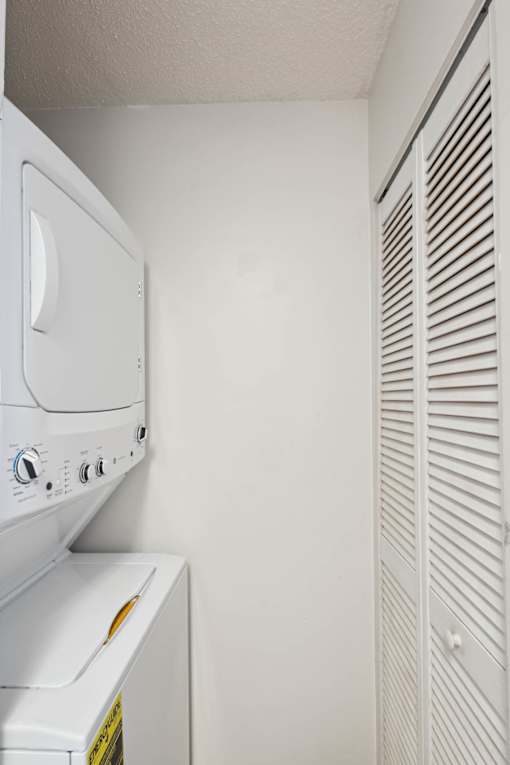 A white washing machine and dryer in a small laundry room.