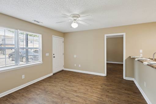 A room with a ceiling fan and a window with blinds.