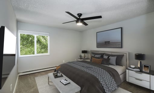 the master bedroom has a large bed and a ceiling fan