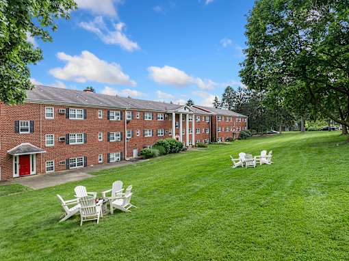 A red brick building with white chairs in front of it.