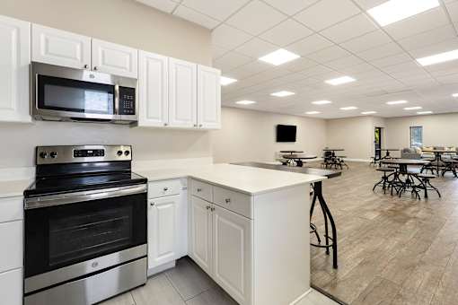 A kitchen with white cabinets and a black stove top oven.