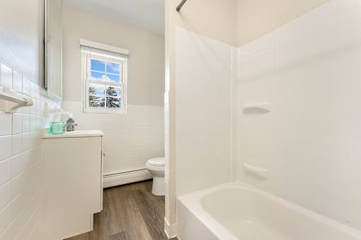 A white bathroom with a tub, toilet and sink.