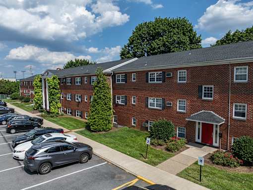 A parking lot with cars parked in front of a brick building.