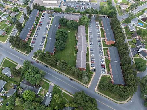A parking lot with cars and apartment buildings.