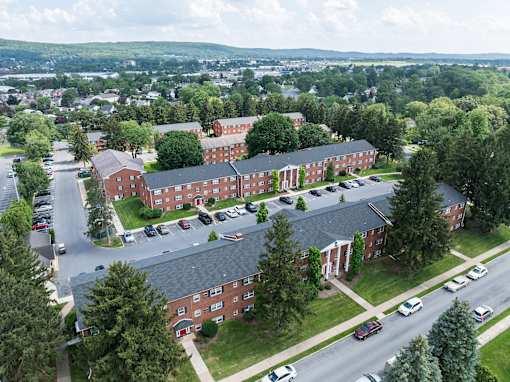 A large red brick building with a parking lot in front.