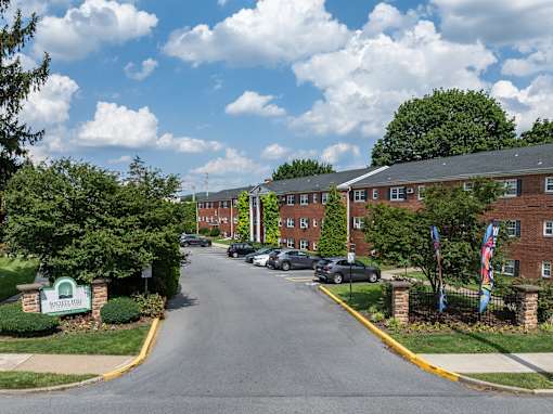A street view of a residential area with cars parked on the side of the road.