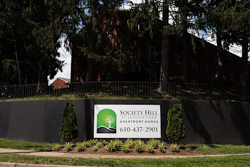 A sign for Society Hill Apartment Homes is displayed in front of a building.