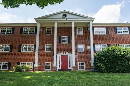 A red brick building with a white door and windows.