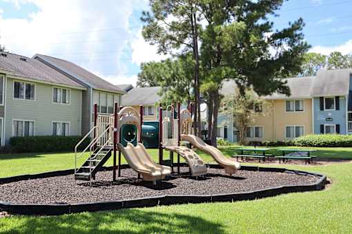 A playground with a slide and a green slide cover.
