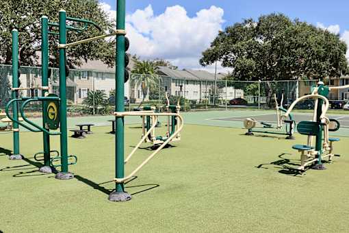 A playground with green equipment and a green fence.