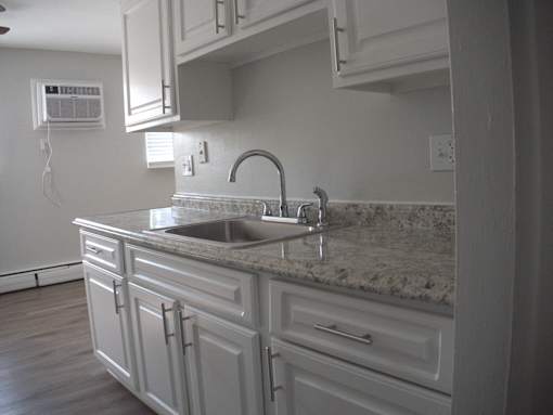 a view of a kitchen with white cabinets and a sink