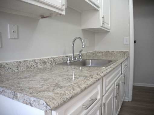 a kitchen with marble counter tops and a sink