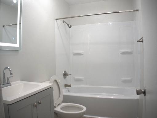 a small bathroom with a shower toilet and sink