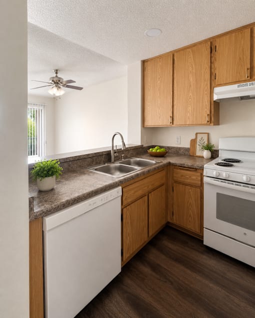 A kitchen with white appliances and wooden cabinets.