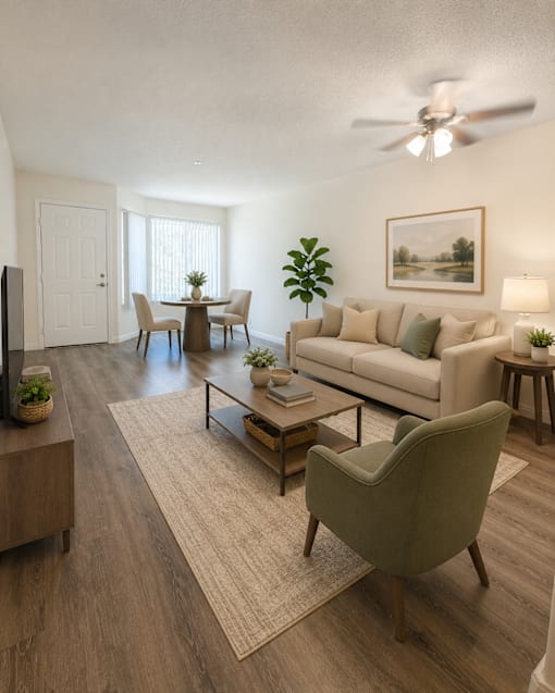 A living room with a couch, chairs, and a television.