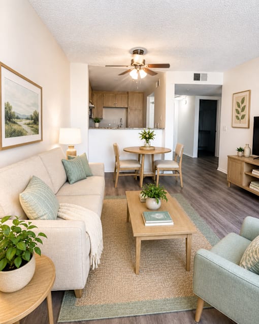 A living room with a couch, a coffee table, and a ceiling fan.