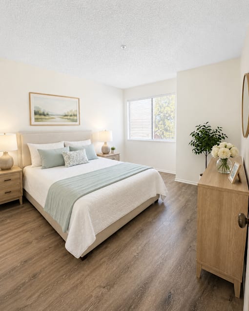A bedroom with a large bed and a painting on the wall.