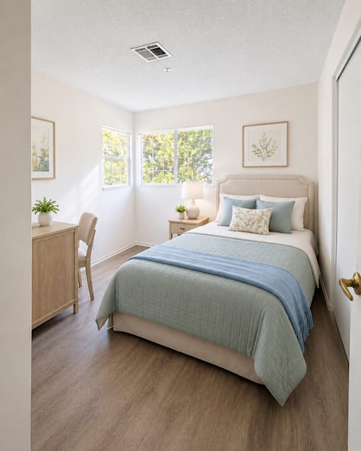 A bedroom with a bed, chair, and window.